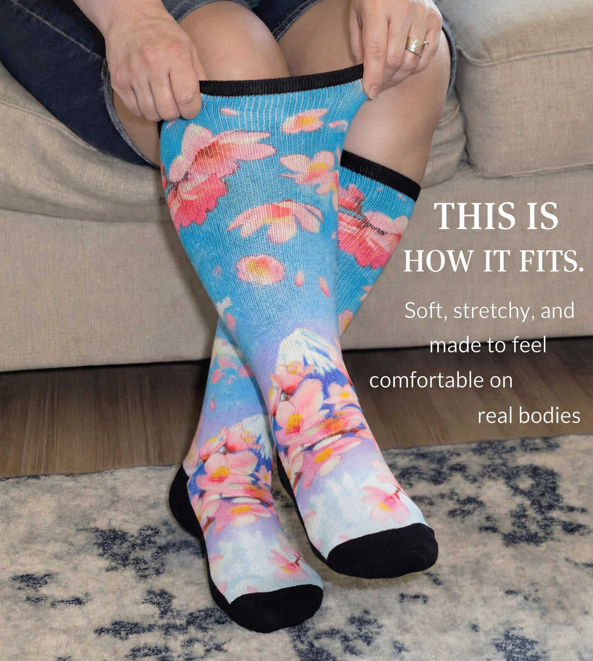 Woman stretching the cuff of Gooi Cherry Blossom extra wide socks, soft stretchy non-binding fit