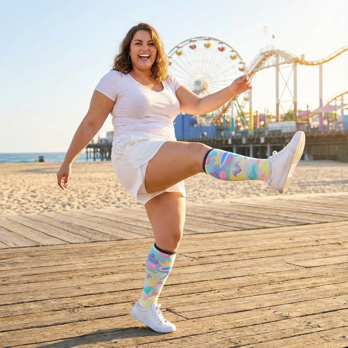 Woman kicking on the beach in Gooi Crown Heart extra wide knee-high socks